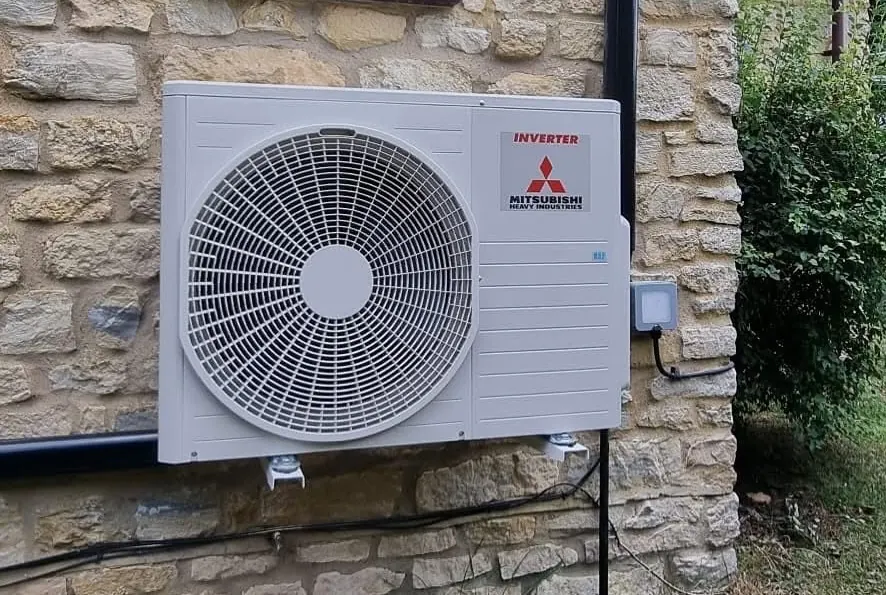 Mitsubishi Heavy Industries inverter outdoor unit installed on a stone wall by ATKINSONS
