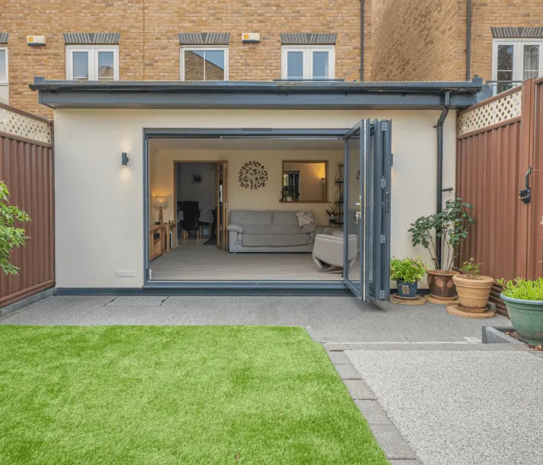 Rendered single-storey rear extension with open bifold doors built by ATKINSONS