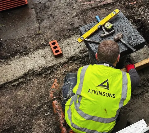 ATKINSONS groundworker laying drainage on site