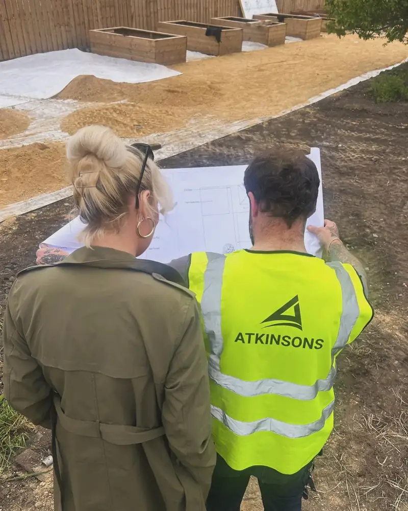 ATKINSONS site manager going through the plans with a customer on a landscaping job
